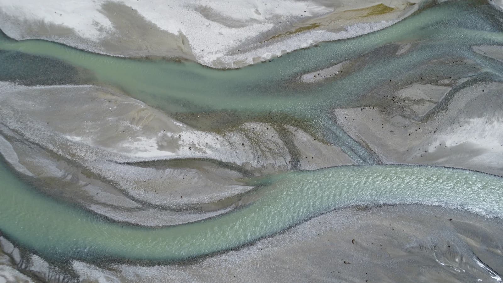 Top-down aerial view of turquoise braided glacial river channels